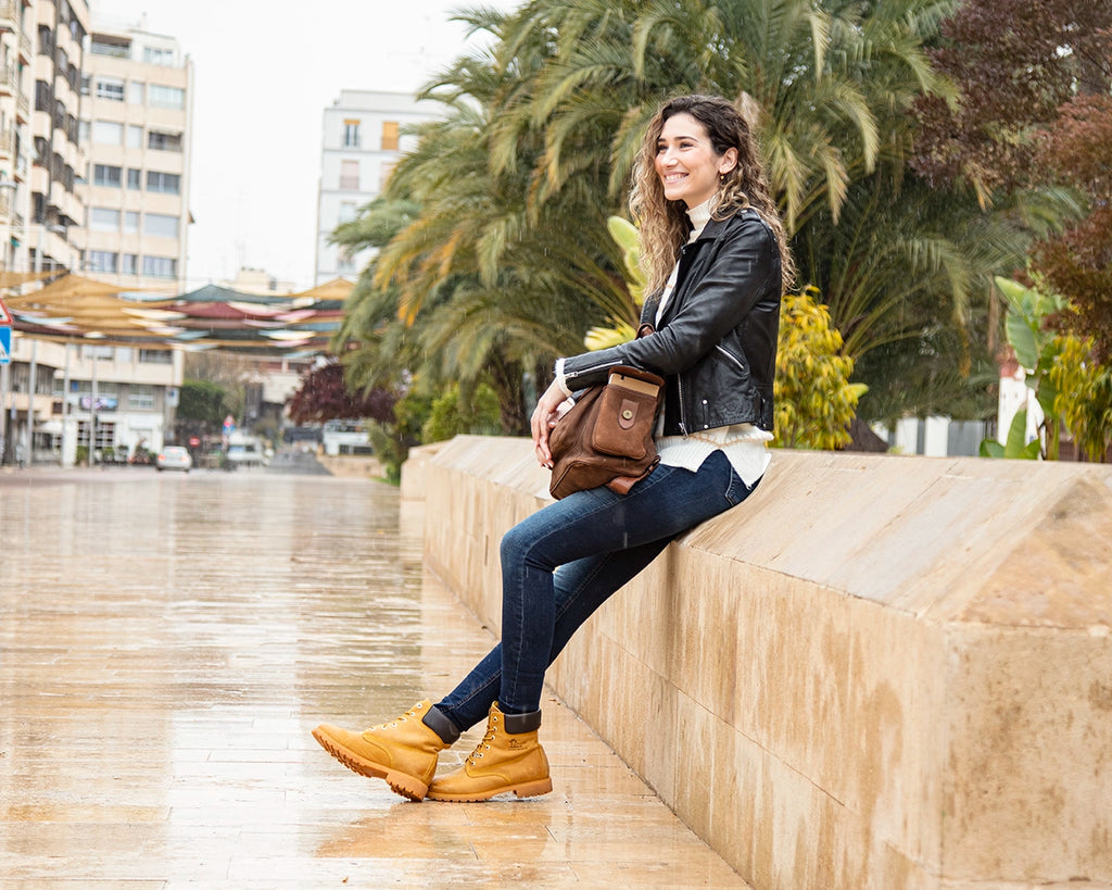 Chica sonriendo bajo la lluvia con unas bota Panama Jack
